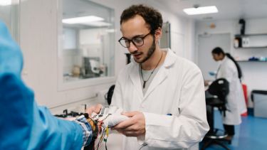 Photo of researcher applying a glove used to monitor function of a hand