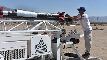 Photograph of team member mounting rocket onto launch rail