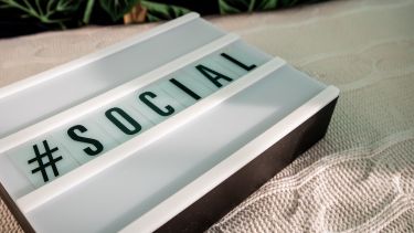A sign saying #social on a white blanket 