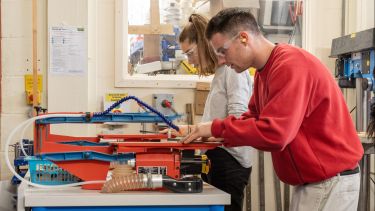 Two students using the facilities in the workshop as part of their induction