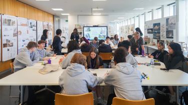 Students sat at tables in a university subject taster session.  