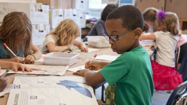 Young school children completing written tasks