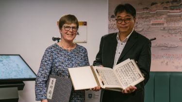 Academics at opening of Window of Korea holding a Korean book