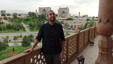 Frank Maracchione standing on a balcony in front of the Samarkand city