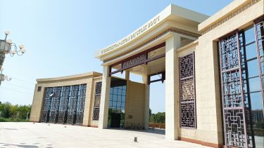 Entrance to Uzbekistan - China Frindship park, a large sand coloured building