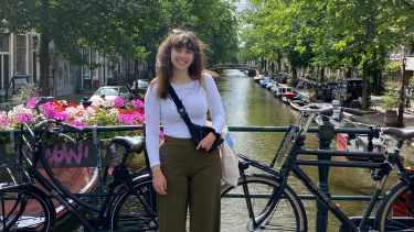 smiling young woman on an Amsterdam bridge in a sunny day