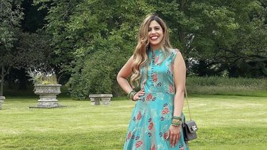 Sukhraj standing in a blue dress in the park.