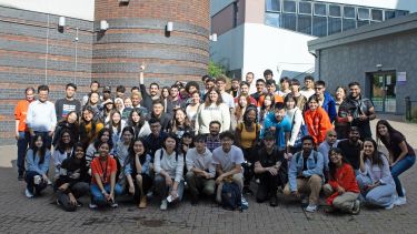A large group shot of international students huddling to celebrate Orientation Week