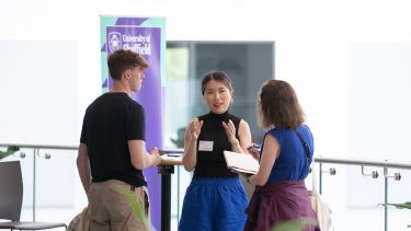 A parent/support with their child talking to staff at an open day