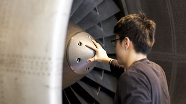 Student touching an engine turbine