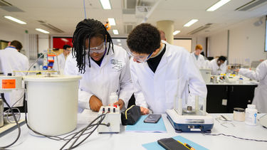 Two students in the Analytics lab in the Diamond in lab coats