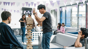 Student plays jenga in the courtyard cafe