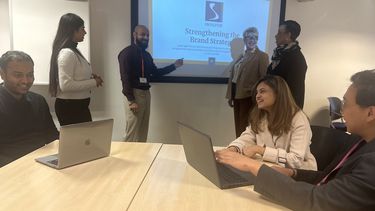 A team of MBA students presenting to The Source