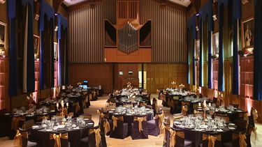 Firth Hall filled with circular tables nicely decorated for a large dinner