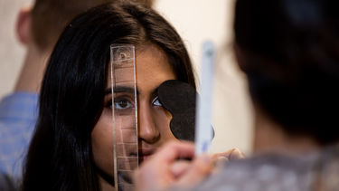An ophthalmology student gets her eye examined by a fellow student