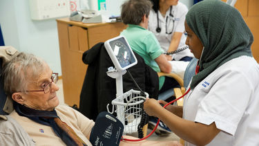 A Nursing student takes a patient's blood pressure 