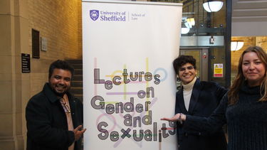 Speaker Gee having a photo with organisers Surabhi and Ella. The Lecture on Gender and sexuality banner is in-between the group with Surabhi and Ella on the right and Gee on the left.  