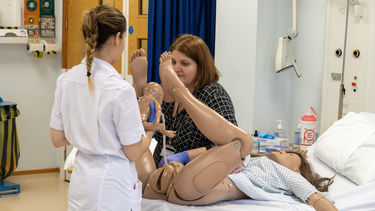 A Midwifery student demonstrates a difficult birth on a manikin