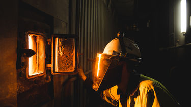 An engineer looking into a glowing biomass furnace