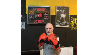 Ian wearing boxing gloves in a fighting position.