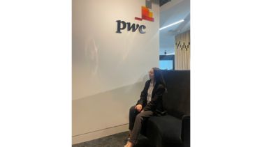 Anett sat by the PwC logo on the wall.