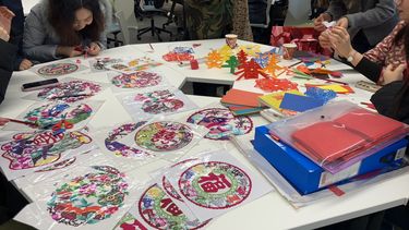 Event attendees enjoy Chinese paper cutting