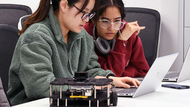 Two students studying computing and robotics