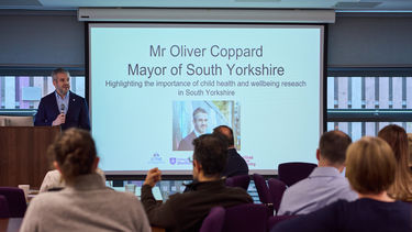 Oliver Coppard next to screen 