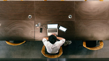 Overhead shot of a student sitting in front of a laptop. 