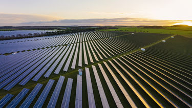 Aerial photo of a solar panel farm in fields.