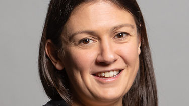 Head shot of Lisa Nandy smiling against a grey background