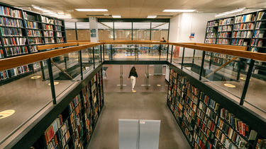 A large panoramic shot of the interior of a library, with many bookshelves on multiple floors