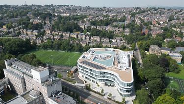 An aerial photo of The Wave and other university buildings against the backdrop of Sheffield