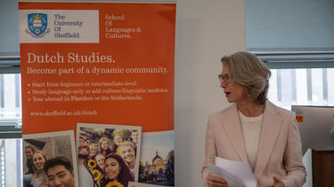 Astrid de Vries of the Netherlands embassy speaks with banner in the background