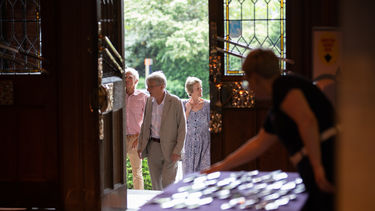 Two men and a woman arrive at Firth Hall for a University-organised reunion. 