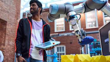 A student using a robot arm in a competition