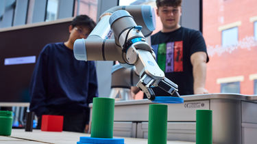 Students competing in the robot arm competition 