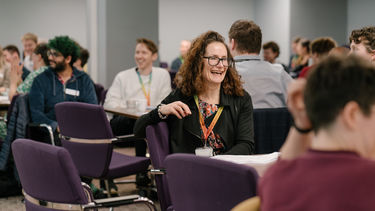 Staff member laughing with colleagues in a workshop