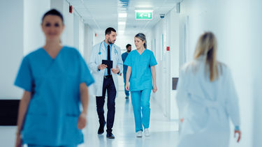 Hospital staff having a discussion whilst walking through a corridor
