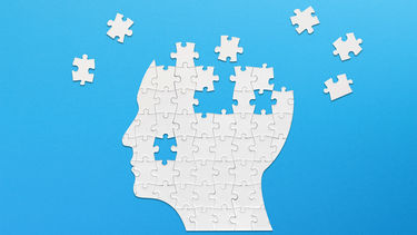 Brain shaped white jigsaw puzzle on blue background. Mental health and problems with memory.