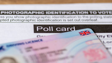 An out of focus driving licence on top of a UK poll card.