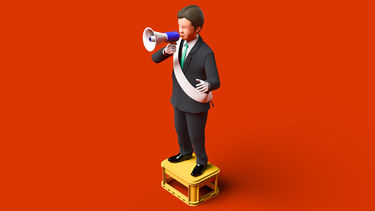 A toy figure of a man standing on a box holding a megaphone in front of a red background.