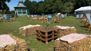 Blue ski, trees, Small bandstand, Blue and white striped deckchairs hay bales and grass