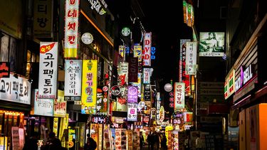 South Korean street lit at night with many shop signs