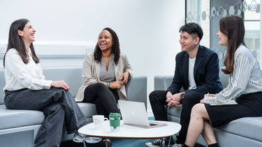 Four MBAs chatting on two sofas.