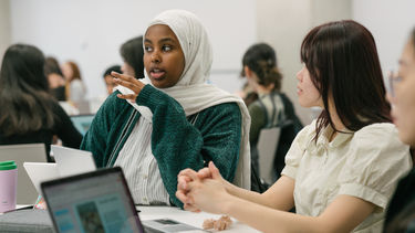 Woman in a white headscarf talking in a seminar room