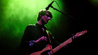 A musician on stage playing a guitar