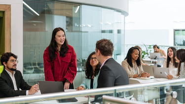 Groups of students sat at tables working together.