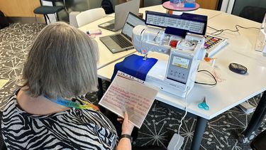 A staff member using a digital stitchcraft machine