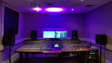 A large mixing console in a recording studio